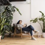 Mujer en sofá rodeada de plantas