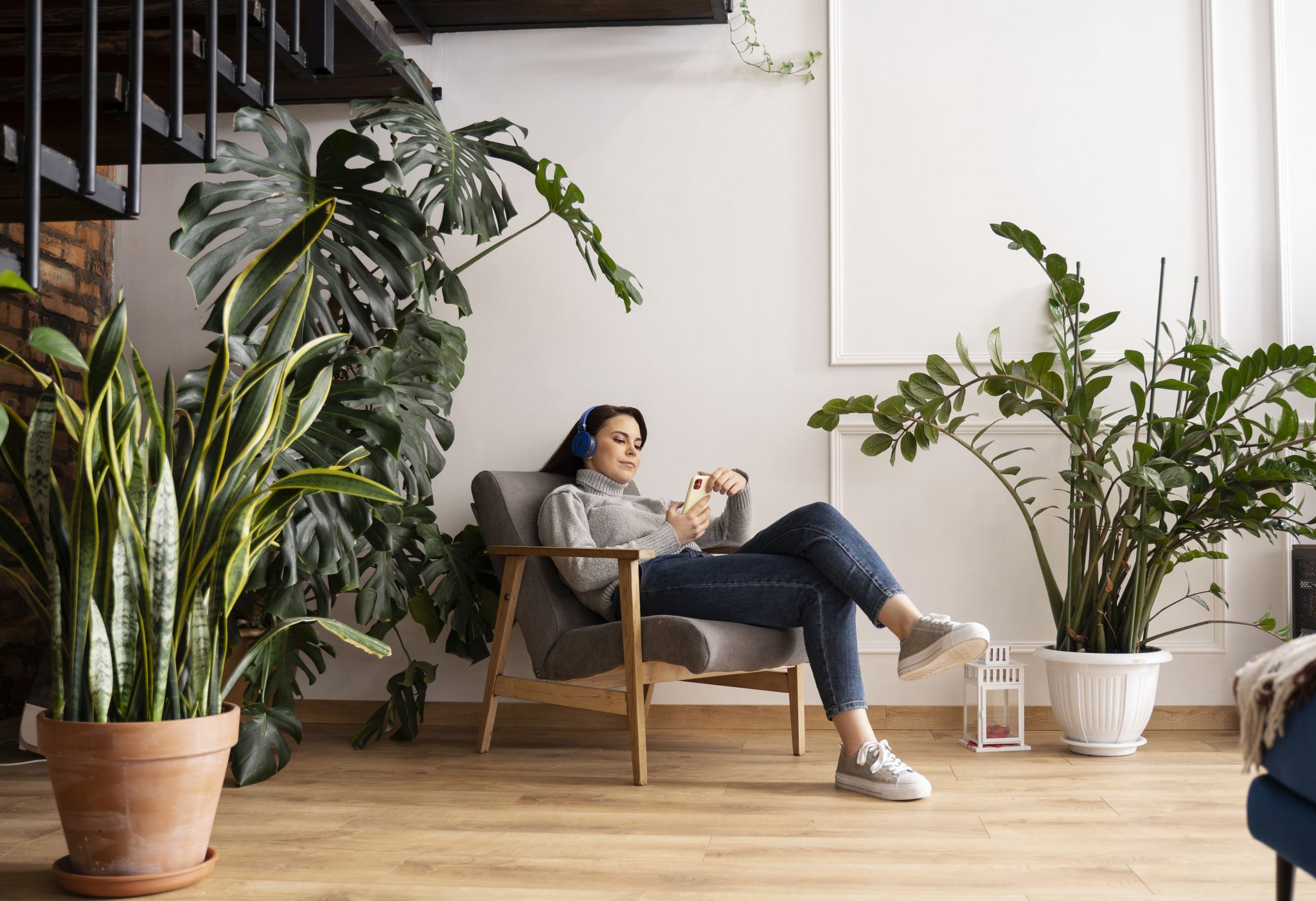 Mujer en sofá rodeada de plantas